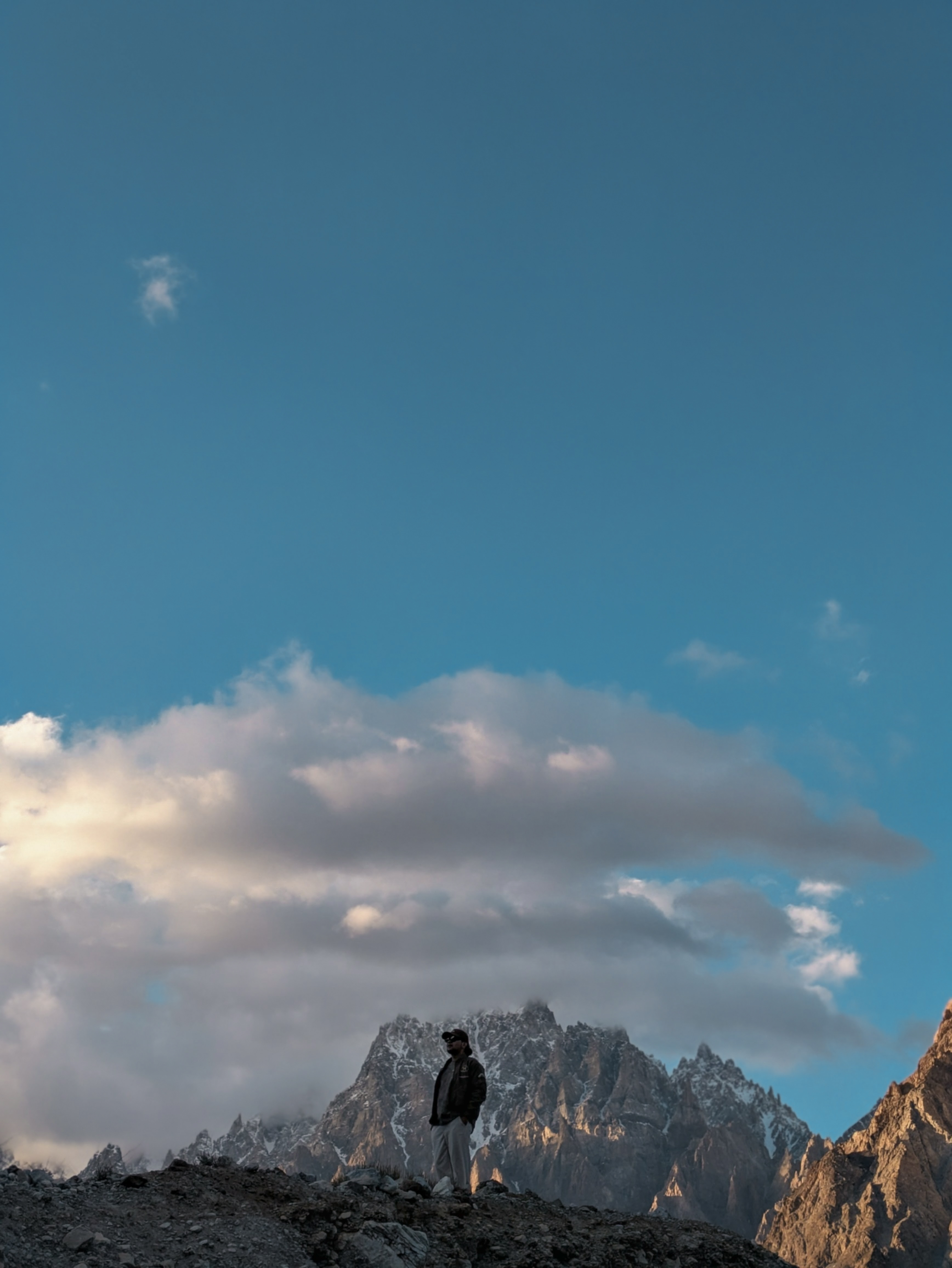 Samie Ullah Baig standing in front of a mountain.