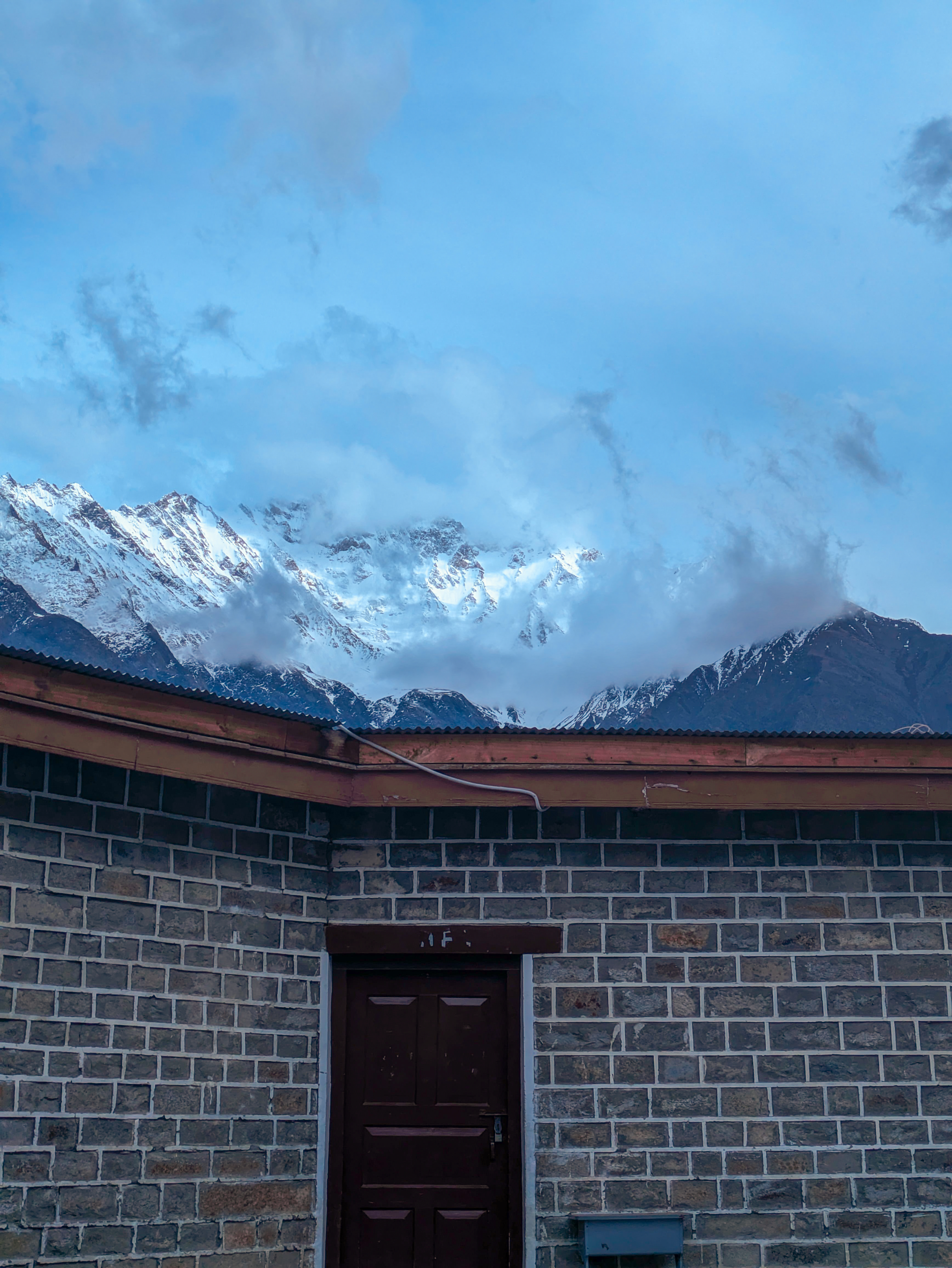 A mountain landscape with a building in the foreground.