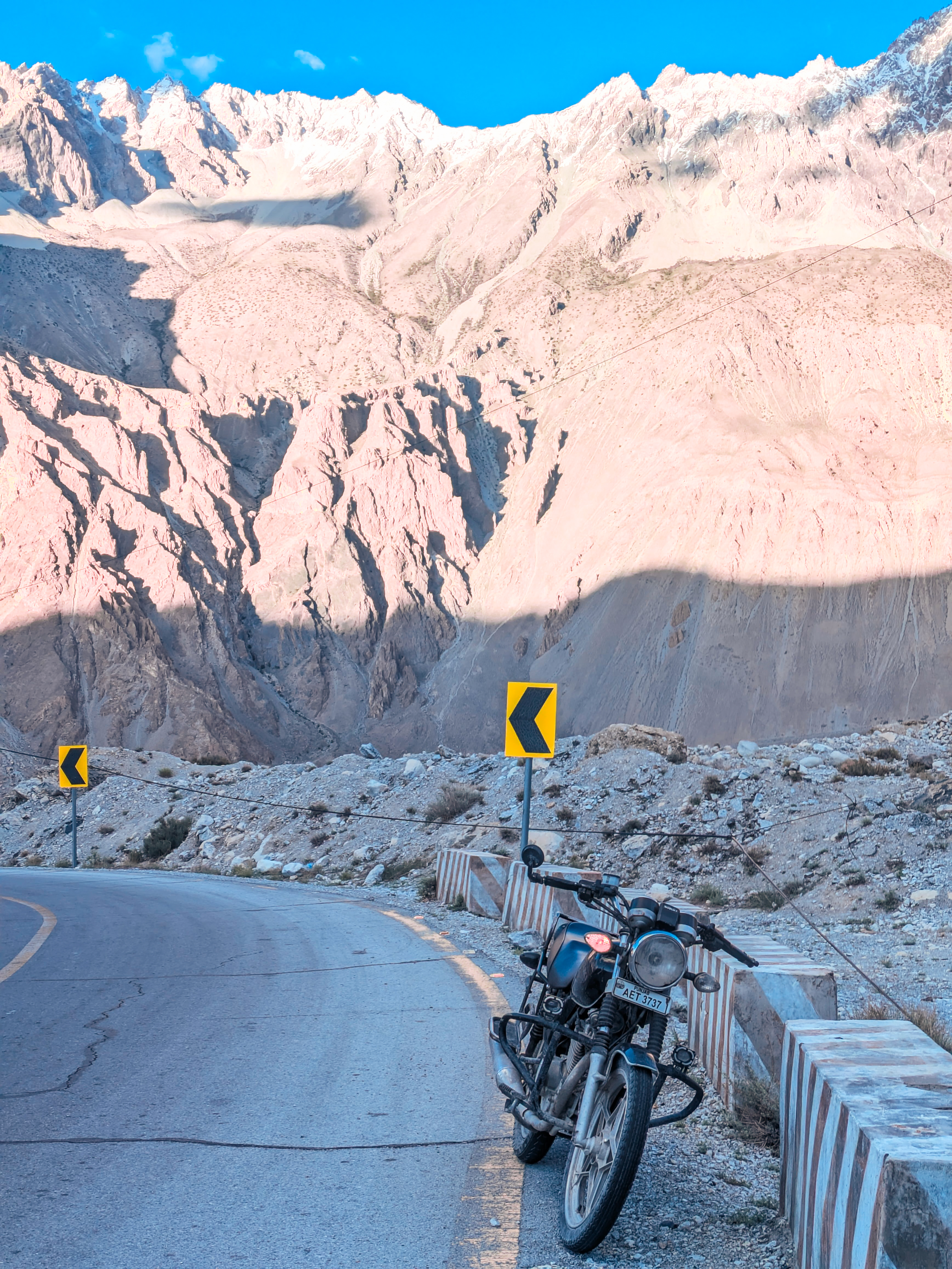 A bike on a road with mountains in the background.