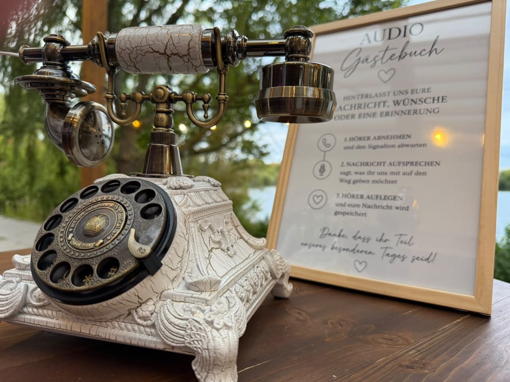 Retro-Audio-Gästebuch neben einem gerahmten Anleitungsschild: Hörer abnehmen, Nachricht aufsprechen und auflegen
