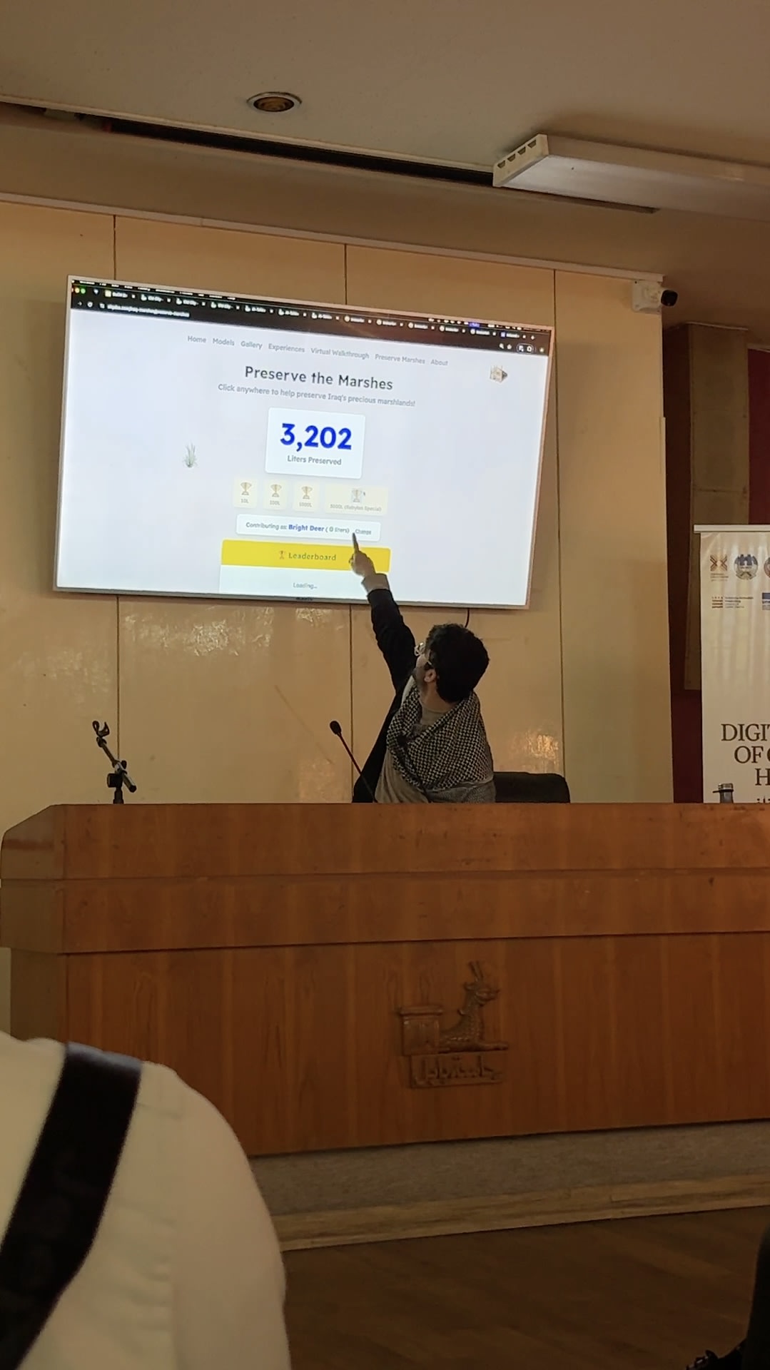 Adil pointing at preserve marshes slide Babylon university