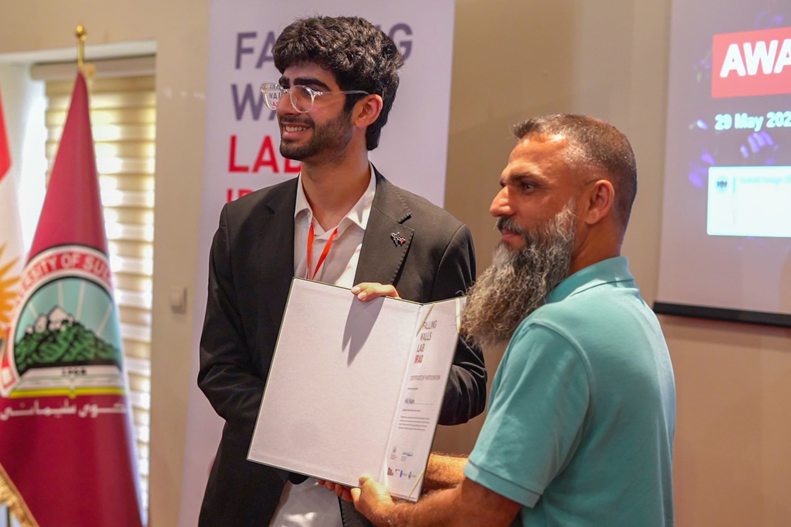 Adil receiving 2nd place certificate in Falling Walls Iraq 2025 at University of Sulaimani