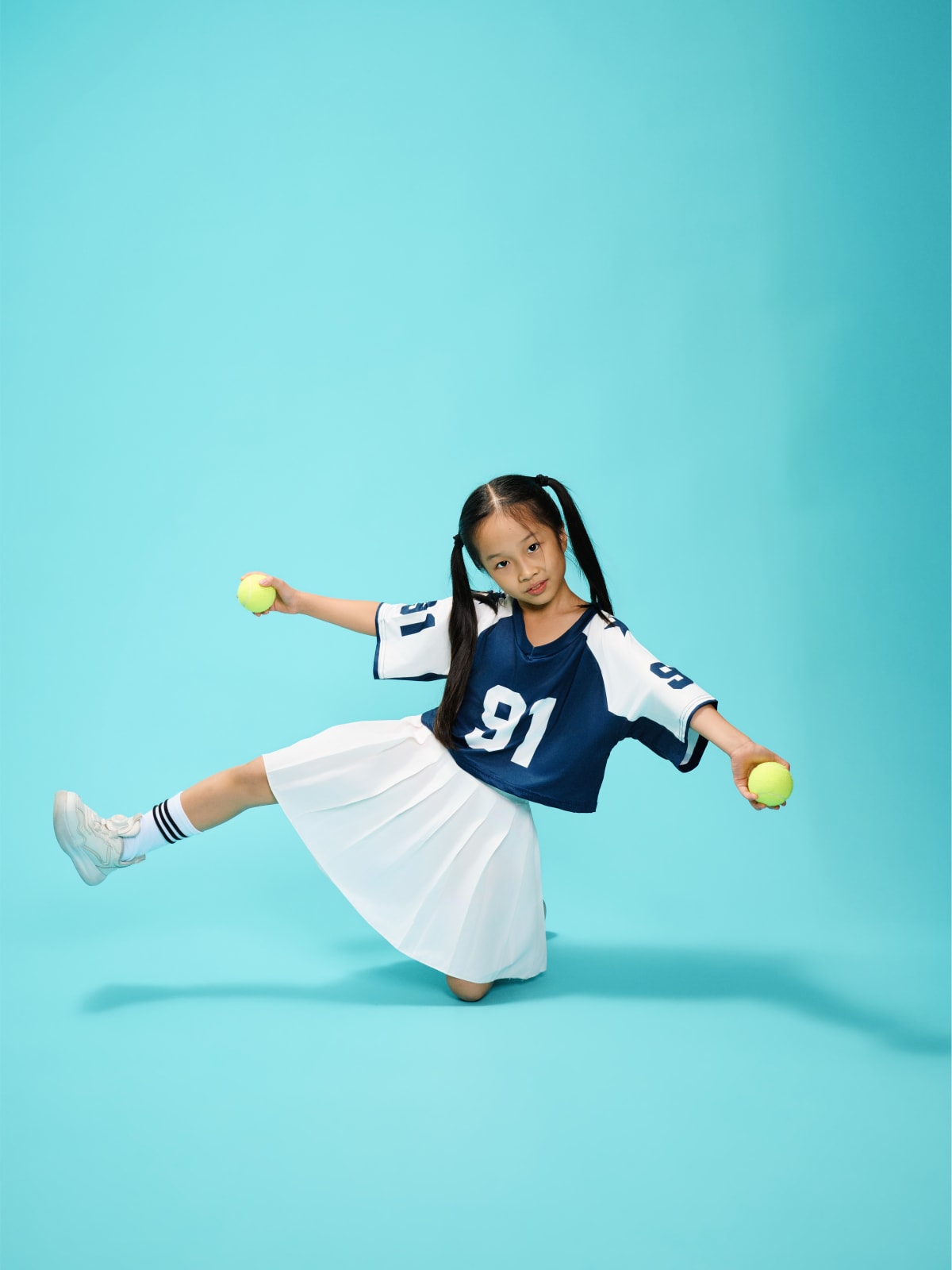 Lunging low across the frame, skirt and limbs thrown wide mid-motion.