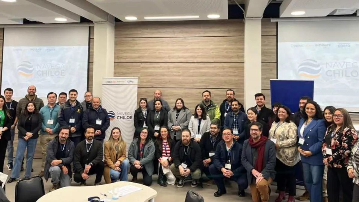 Participantes del programa Navega Chiloé reunidos en una jornada del proyecto, con pendones del programa al fondo