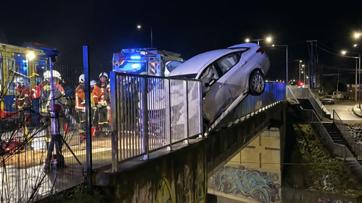 Vehiculo al borde del paso sobre nivel de Puerto Montt con bomberos trabajando de noche