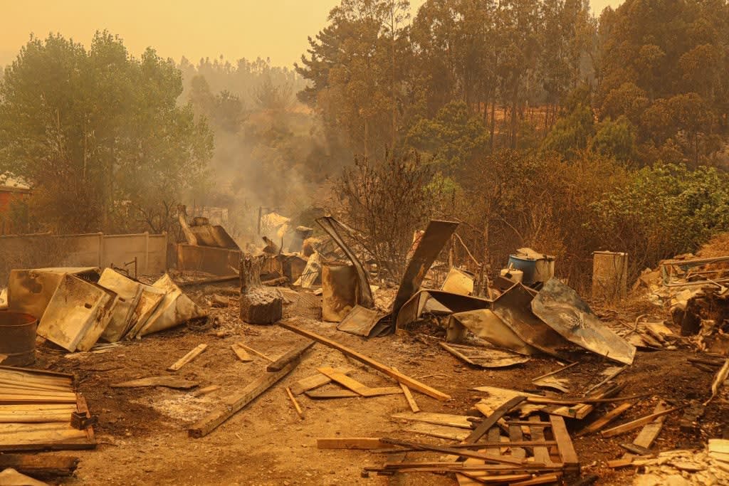 Mujer evacúa en Penco por incendios forestales