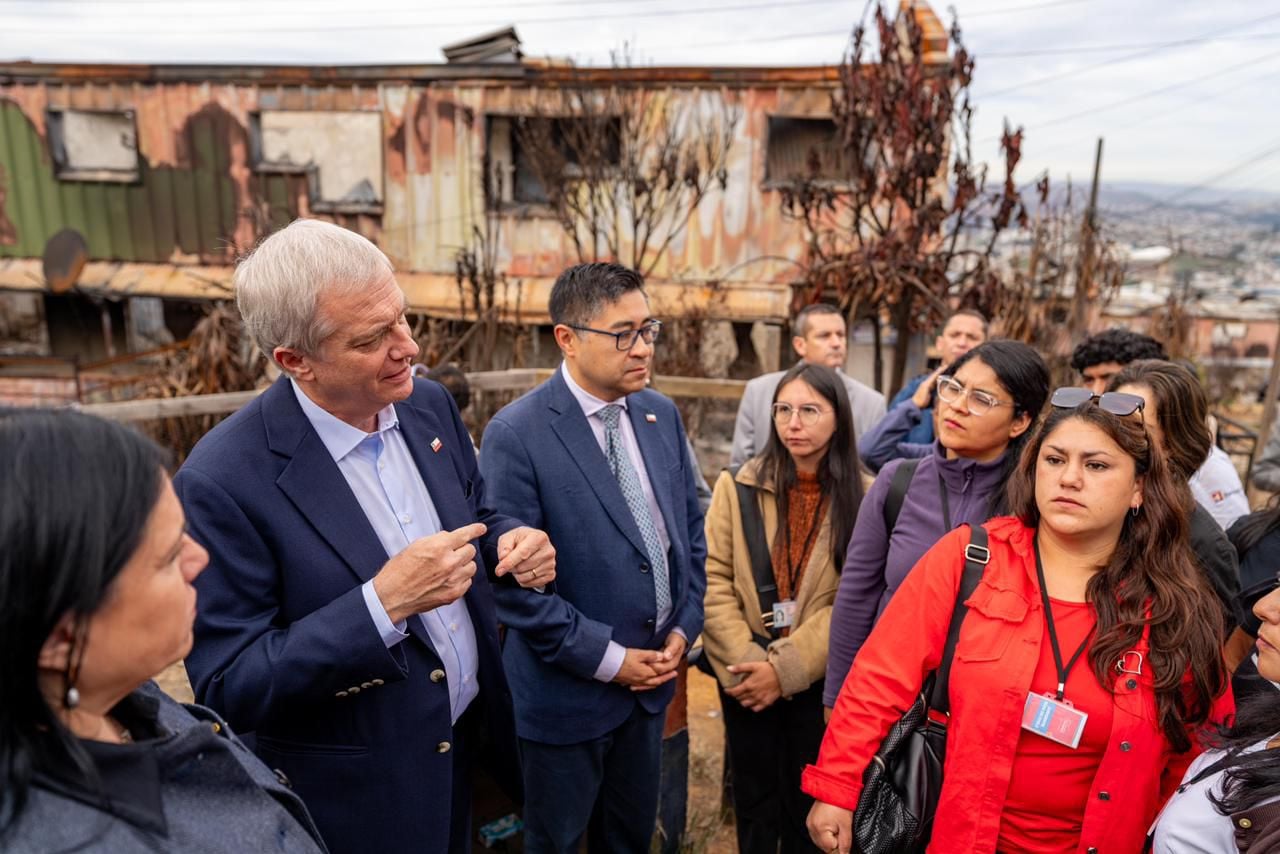 Kast conversa con vecinos y autoridades locales en medio de las viviendas destruidas por los incendios.