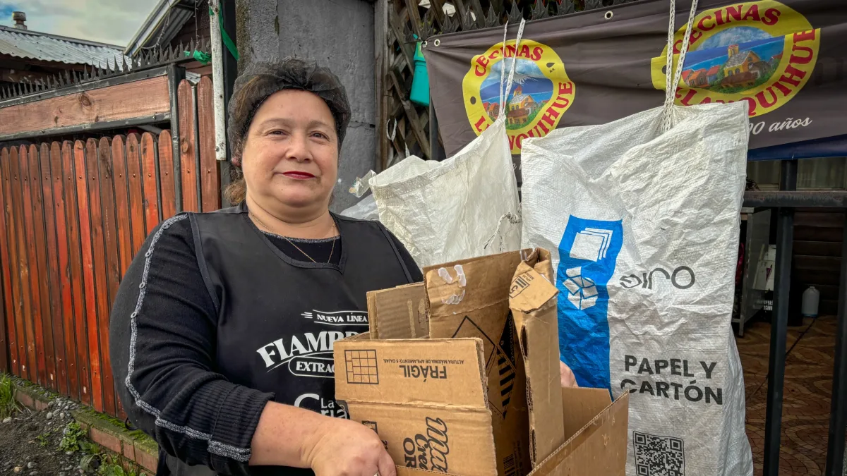 Vecina de la provincia de Llanquihue entrega cartón junto a un saco de reciclaje de papel y cartón