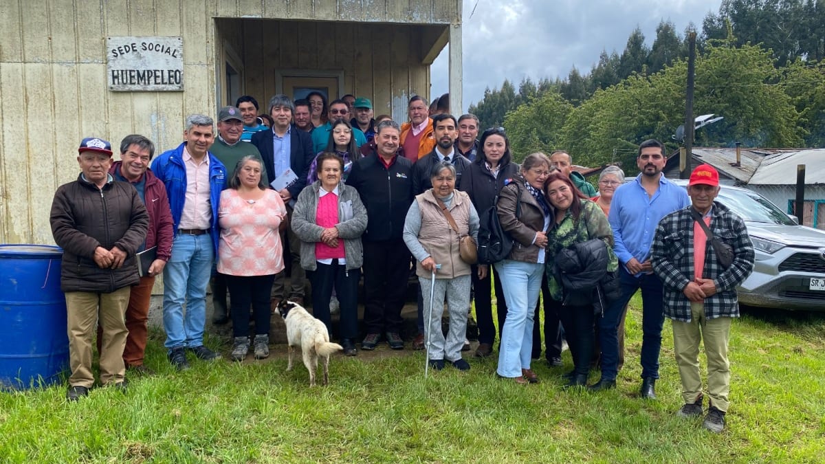 Vecinos y autoridades frente a la sede social de Huempeleo, en Fresia, durante el anuncio de inversión vial