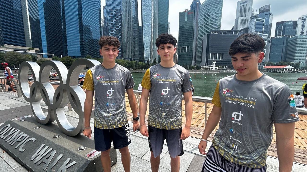 Los tres deportistas del Club Náutico Viento Sur en Marina Bay, Singapur, junto a los anillos olímpicos del Olympic Walk
