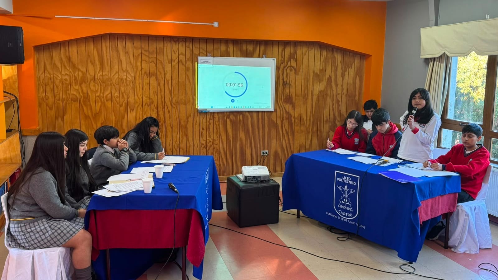 Dos equipos de estudiantes debaten en el Liceo Politecnico de Castro, con el cronometro proyectado en la pizarra