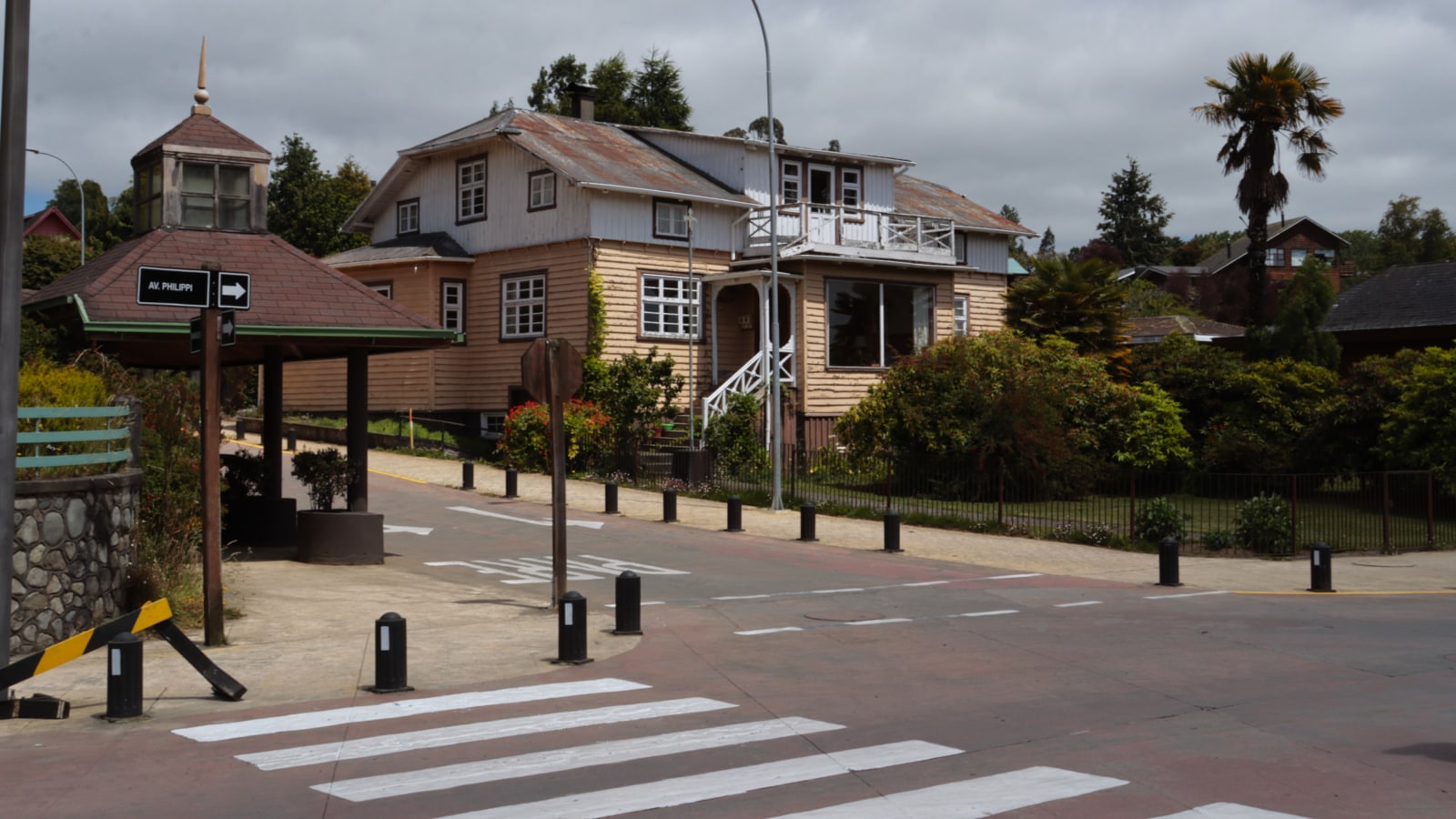 Cruce de la avenida Philippi en Frutillar Bajo, con el letrero de la calle y una casa de arquitectura tradicional al fondo