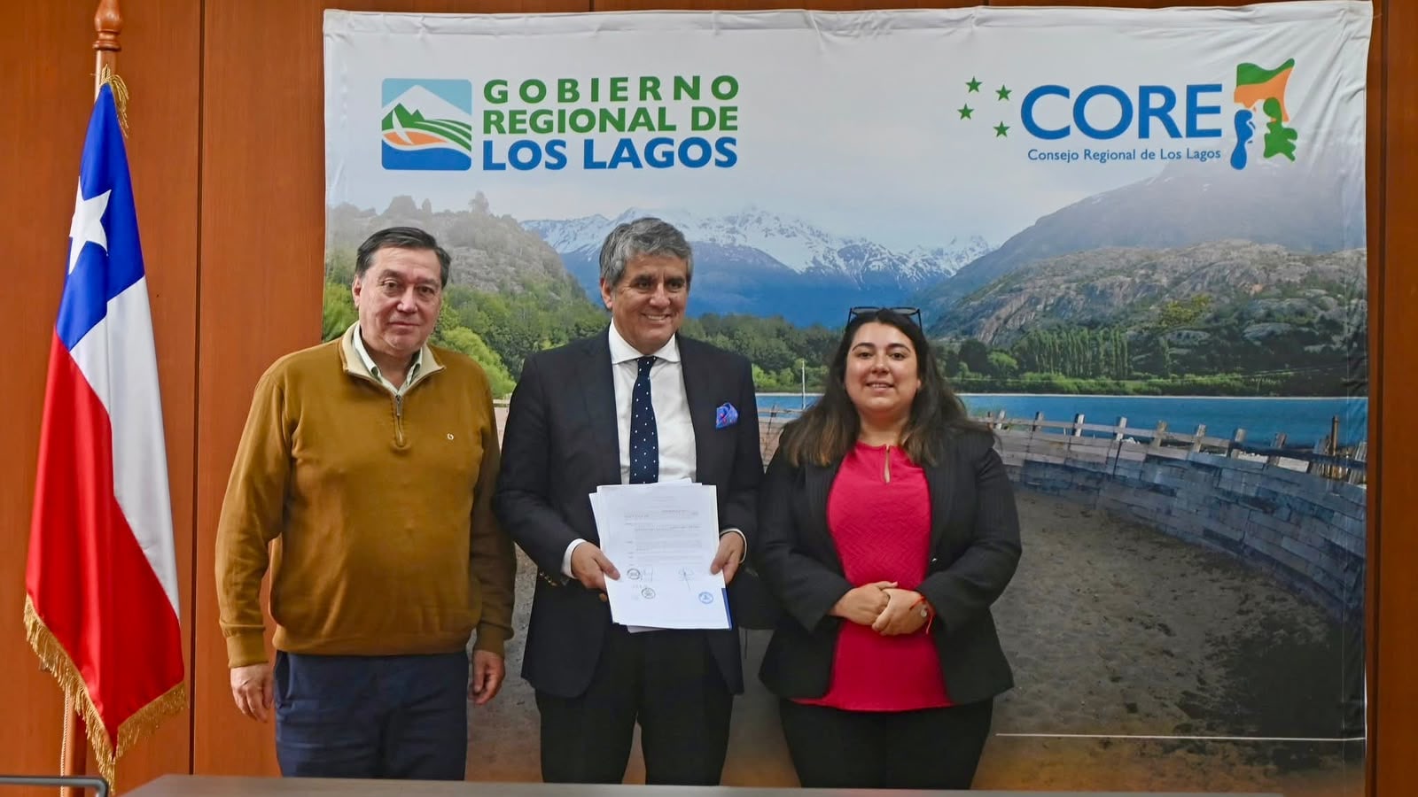 Imagen de archivo: autoridades del Gobierno Regional de Los Lagos con un documento firmado, frente a un pendón institucional