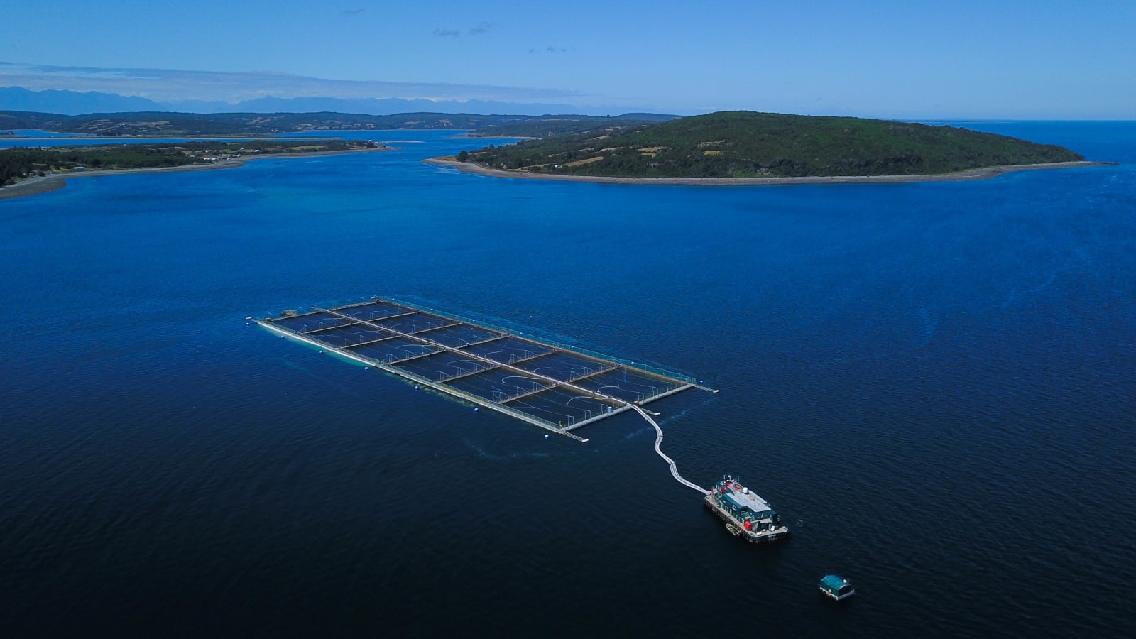 Vista aérea de un centro de cultivo de salmón con su pontón en un canal del sur de Chile. Imagen de archivo