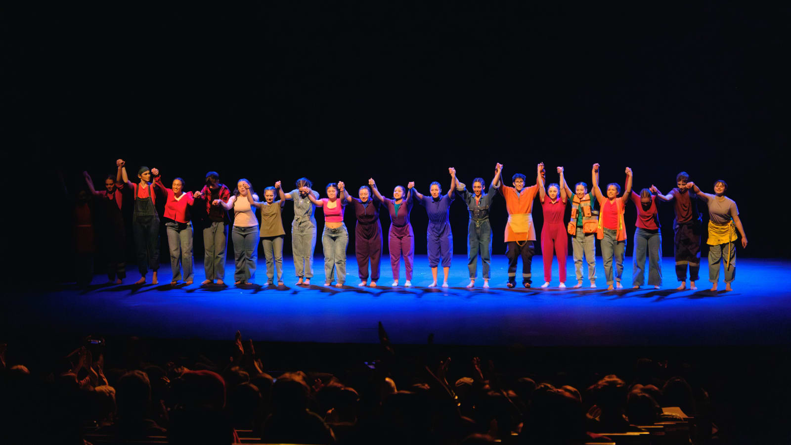 El elenco juvenil de Circo Frutillar saluda tomado de las manos al público al final de La gran feria en el Teatro del Lago