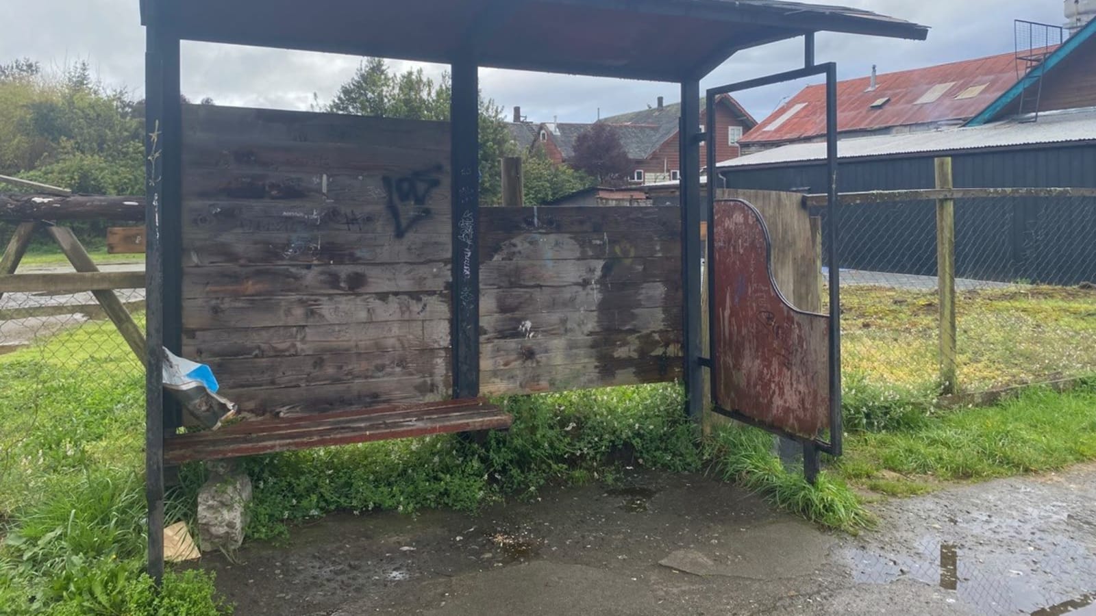 El paradero junto al terminal de buses de Frutillar Bajo, con el panel lateral desprendido, rayados y el asiento dañado