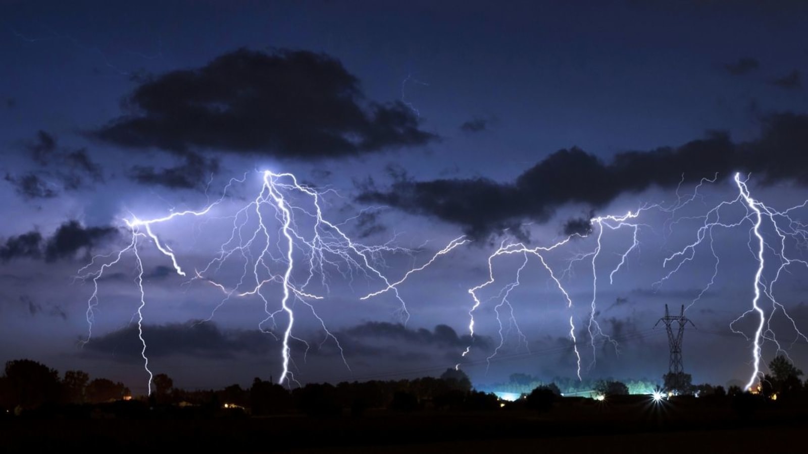 Descargas eléctricas iluminan el cielo durante una tormenta nocturna, imagen de archivo
