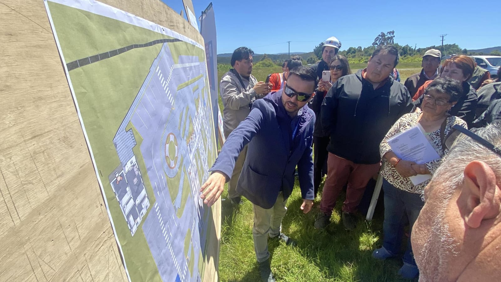 Autoridades y vecinos revisan los planos del nuevo Cesfam de Bahía Mansa durante la entrega de terreno, en diciembre de 2024. Imagen de archivo.