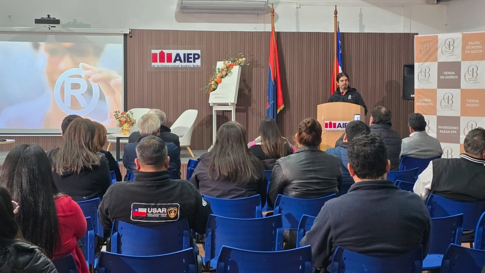 Comerciantes del Barrio Cochrane de Osorno en el Primer Foro de Comercio Local, con el pendón de las tiendas asociadas al fondo