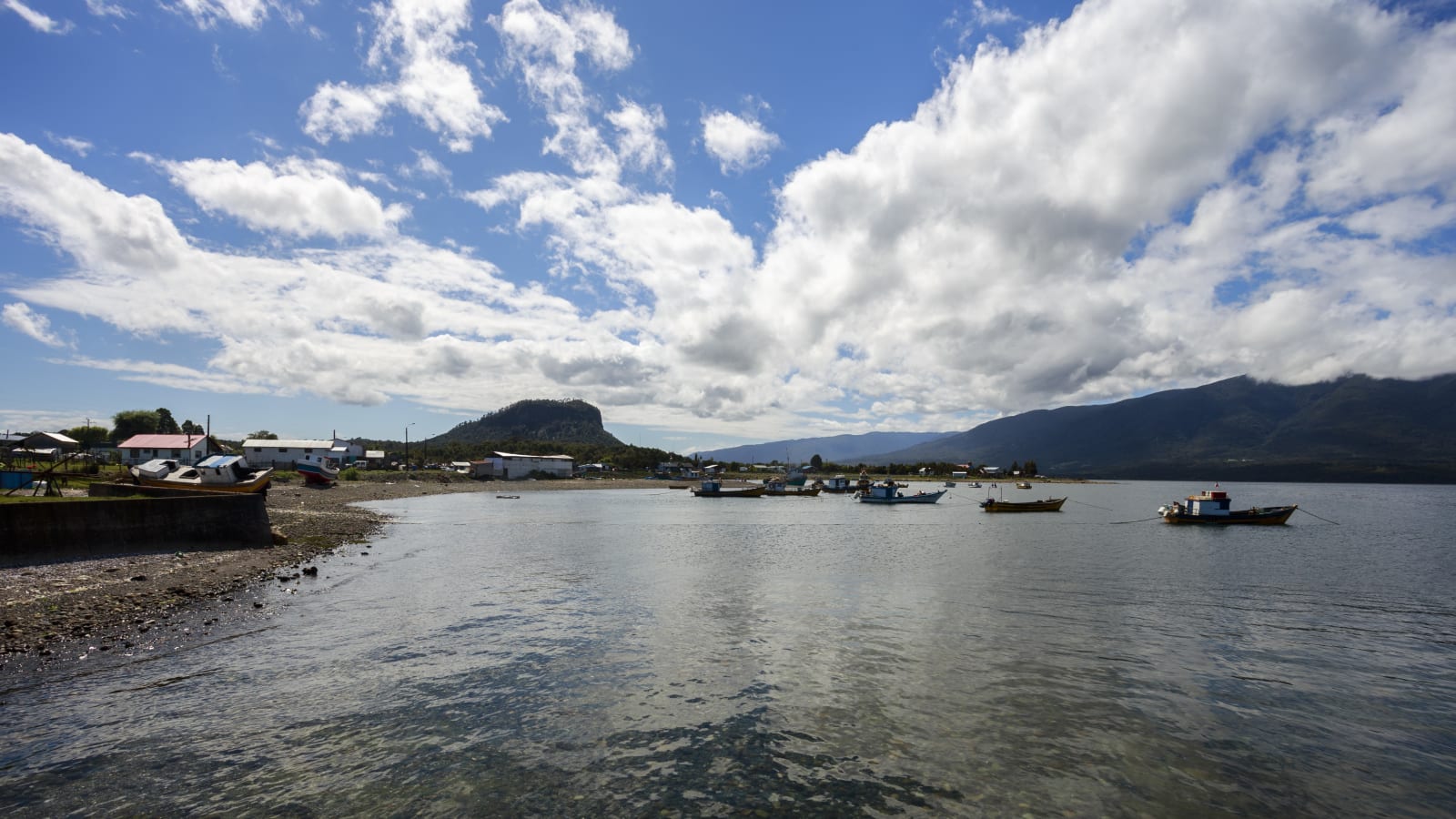 Borde costero de Hualaihué Puerto con embarcaciones de pesca artesanal fondeadas frente a la caleta