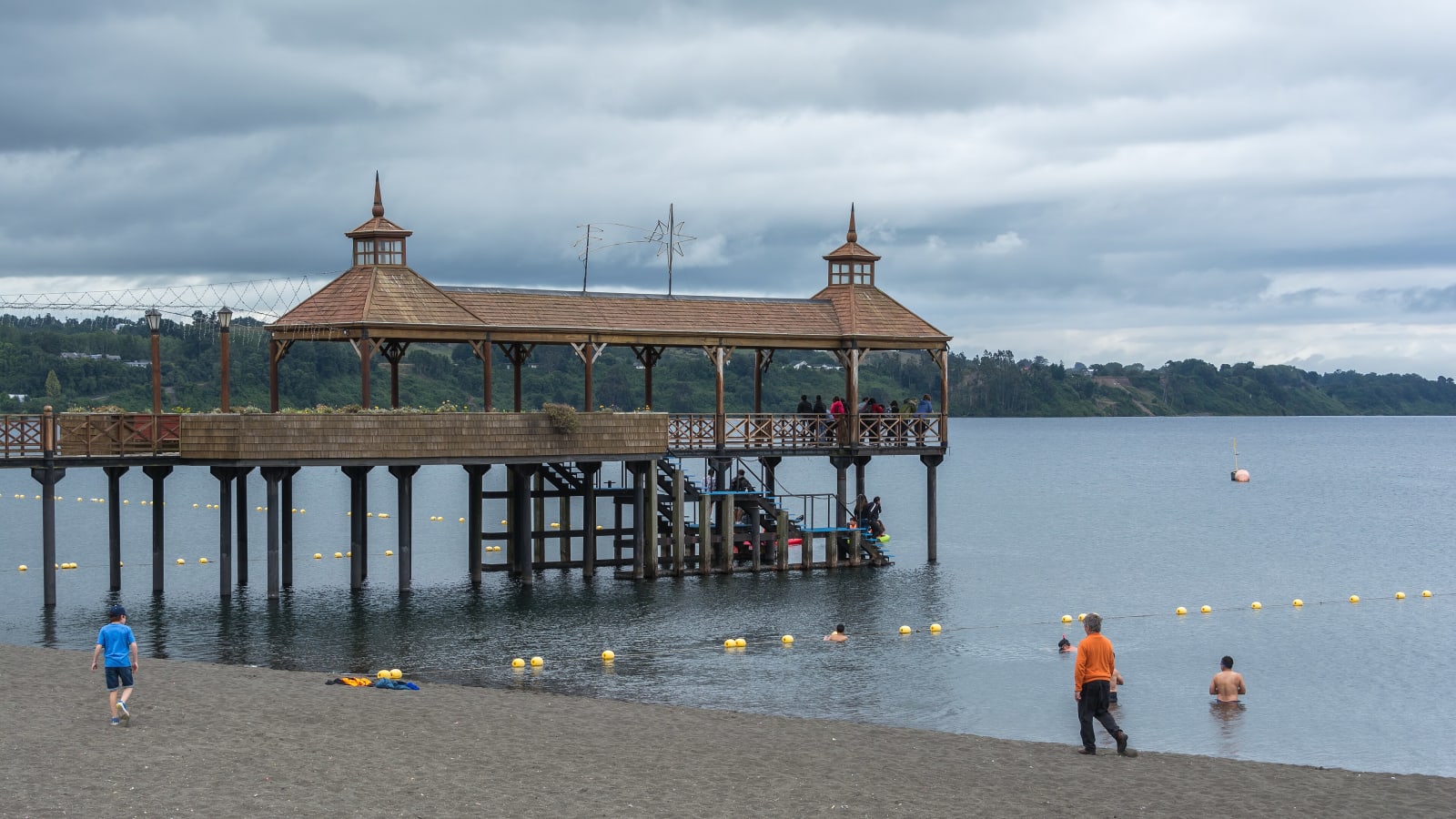 Vecinos y bañistas junto al muelle de Frutillar, en el lago Llanquihue, en un día nublado