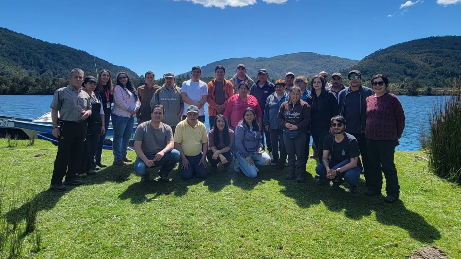 Emprendedores de Caleta Huellelhue junto a funcionarios de Sernatur, el municipio de Río Negro y WWF Chile, a orillas del agua y rodeados de cerros con bosque
