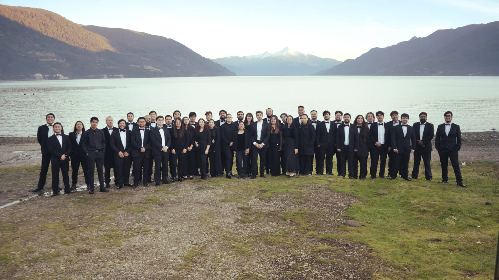 Integrantes de la Orquesta Filarmónica del Lago Llanquihue posan a orillas de un lago del sur