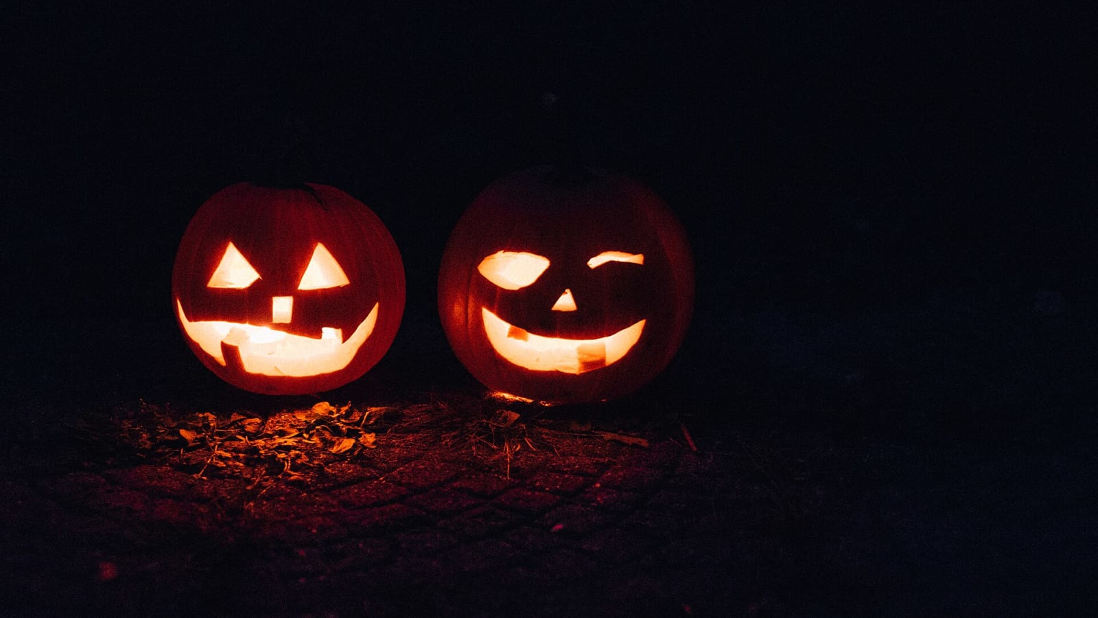Dos calabazas talladas de Halloween iluminadas en la noche (imagen referencial)