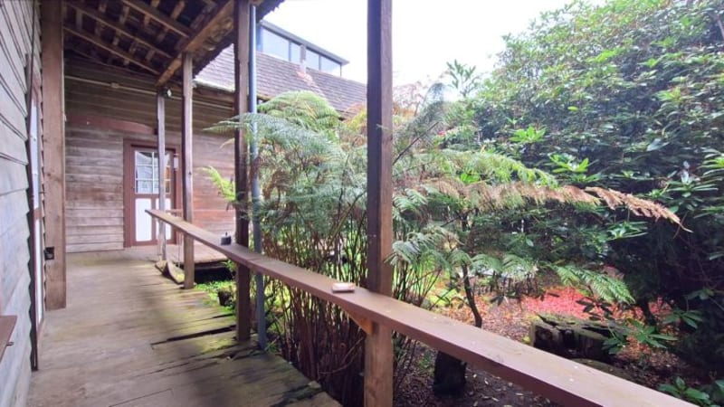 Galería de madera y jardín del patio interior de Casa Raddatz, en Puerto Varas