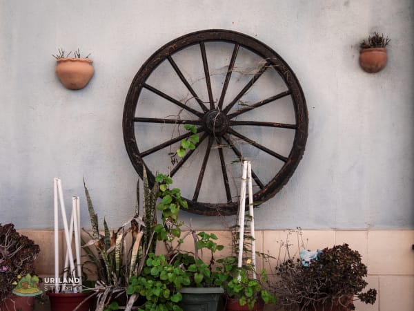 A wagon wheel used as decoration on a village wall