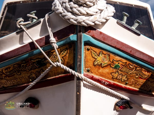 A white luzzu boat in Marsaxlokk harbour