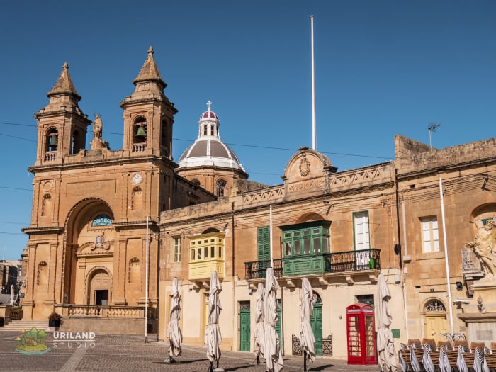 Marsaxlokk's parish church with a small English red telephone box in the foreground