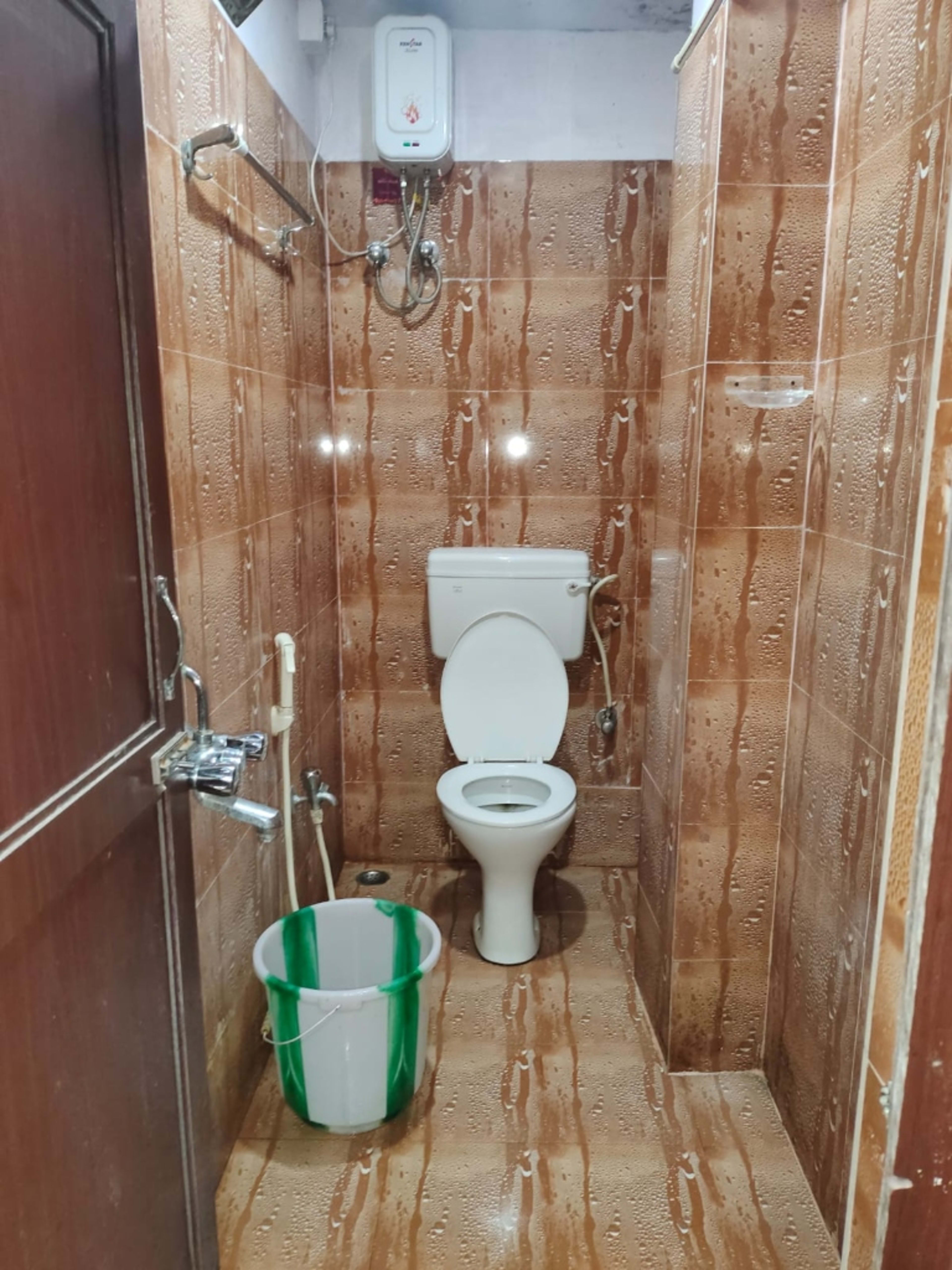 Equipped with wall-mounted water heater (geyser) and clean sanitation fittings.