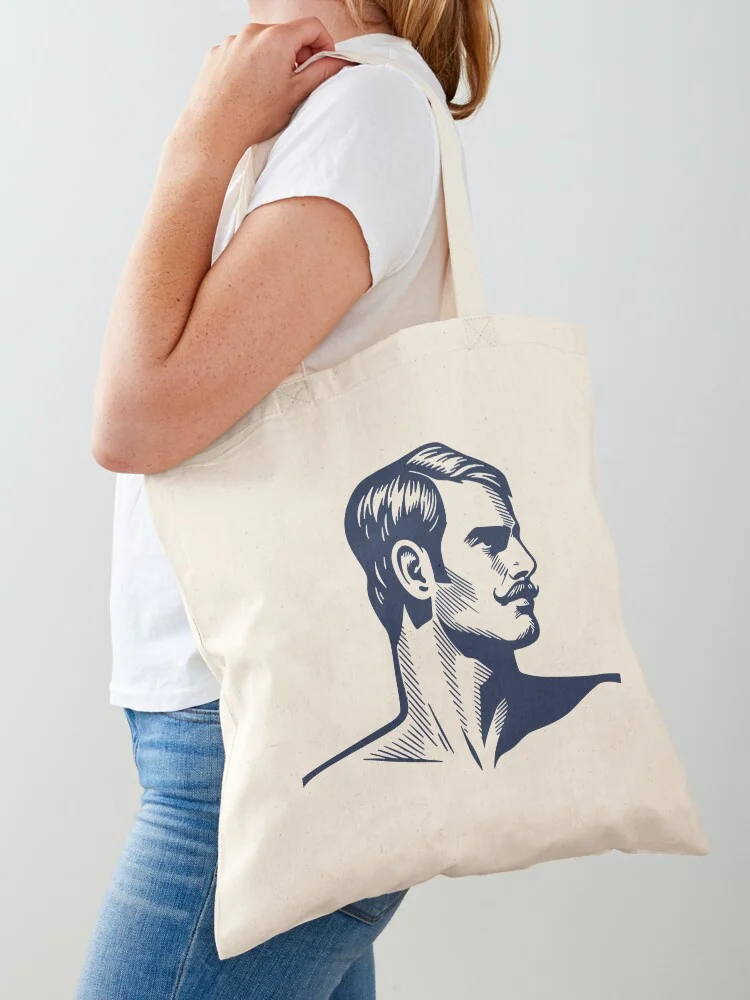 Cotton tote bag worn on a shoulder featuring the handsome male linocut graphic.