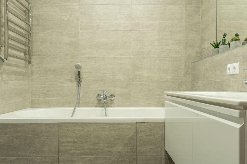 Modern bathroom with a bathtub, showerhead, tiled walls, and a sink cabinet.