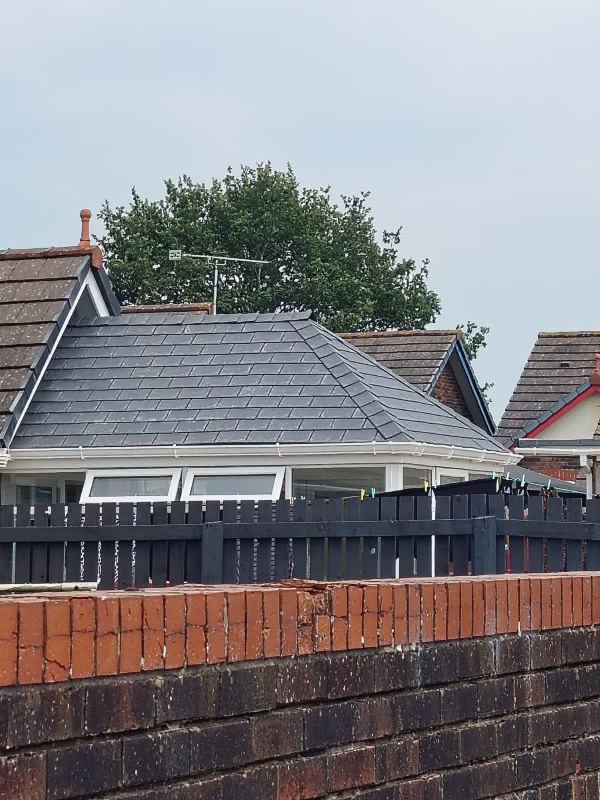 Completed roof by Roof Repairs Southport - a new hipped roof in dark slate-grey tiles with white fascia and guttering on a Southport bungalow
