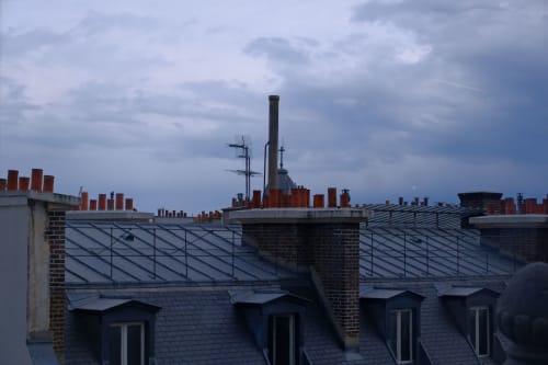 A brick chimney on a tiled roof.