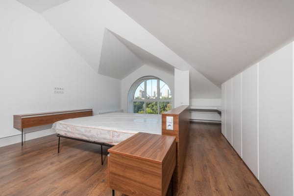 Loft conversion bedroom with sloped ceiling and fitted storage