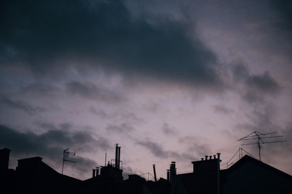 Dark storm clouds gathering over rooftops, the weather that damages Southport roofs