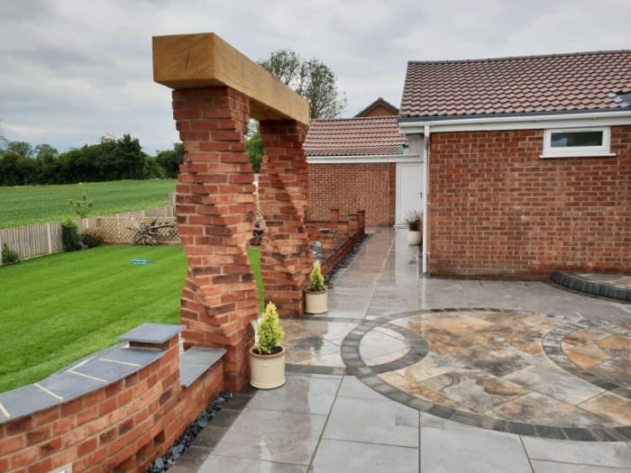 Brick patio with decorative brick columns and a lawn.