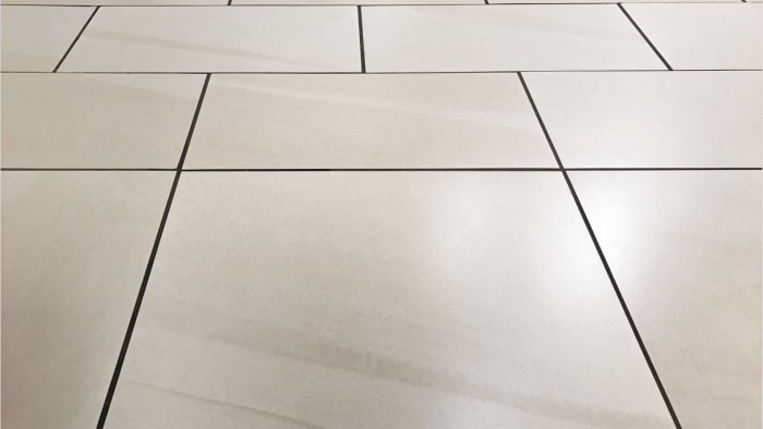 Beige tile floor with dark grout lines, perspective lines.