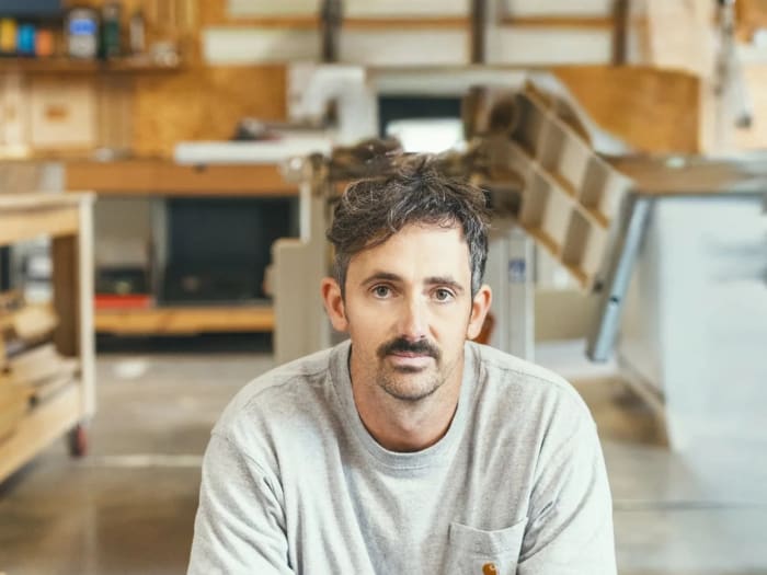 The joiner who makes and fits every piece, photographed in the workshop