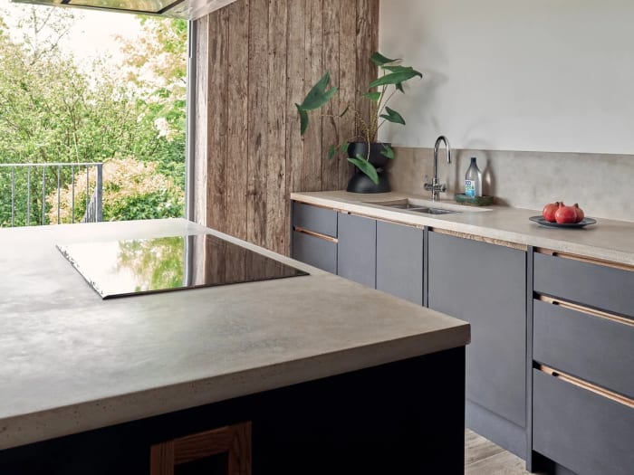 Handmade kitchen with a concrete island top and dark timber cabinets