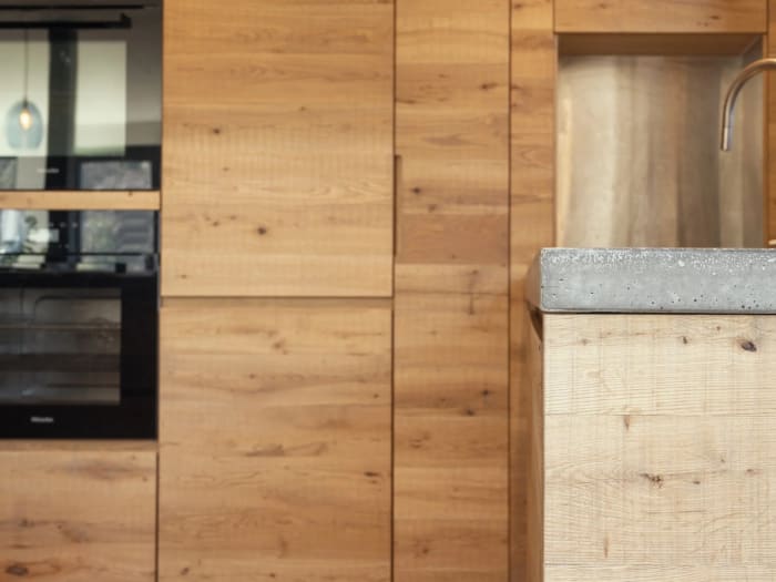 Bespoke kitchen with tall oak units and a stone worktop