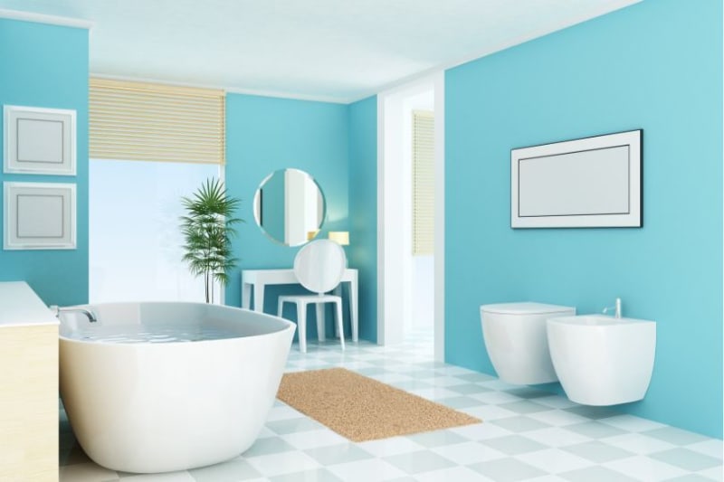 Blue bathroom with a soaking tub, toilet, and vanity.