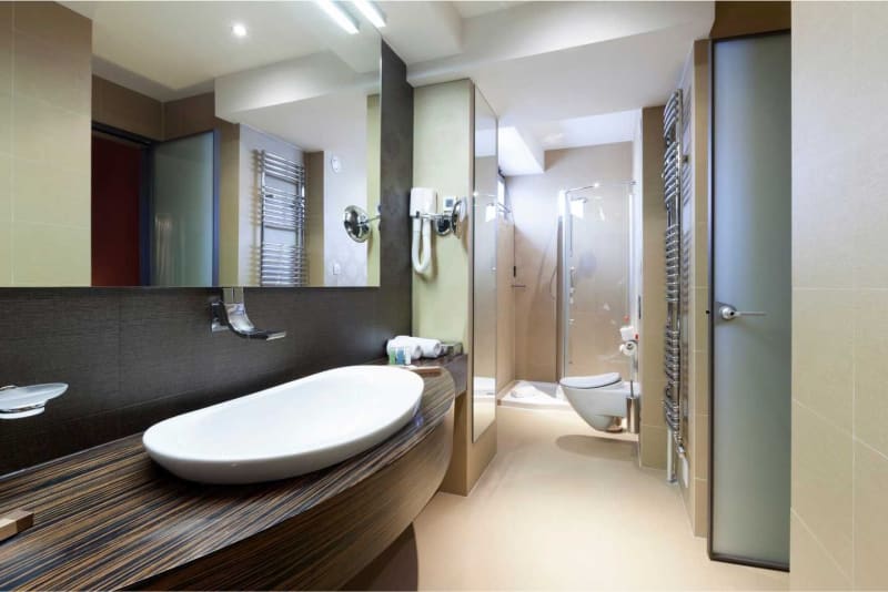 Modern bathroom with a vessel sink, large mirror, and a glass shower door.