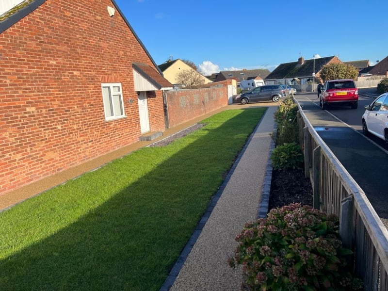 Grass with beige resin pathway surrounding it