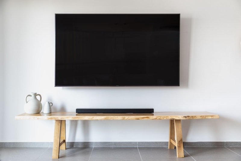 Minimalist media wall with wall-mounted TV and wooden console