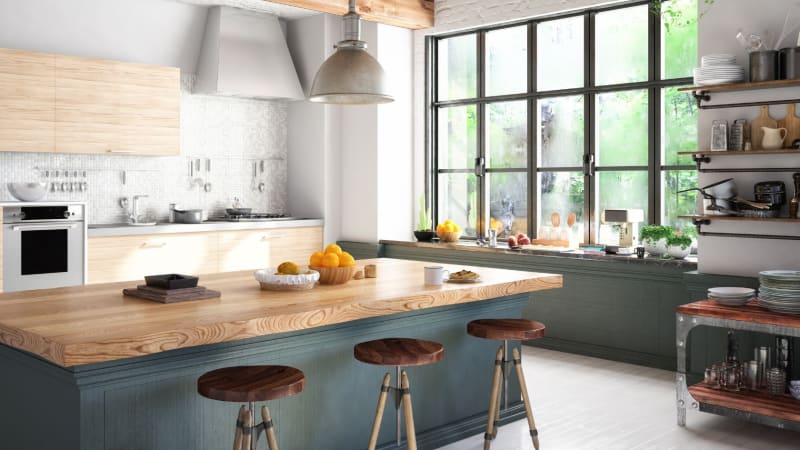 Kitchen with island, stools, large window, natural light, and wooden counters.