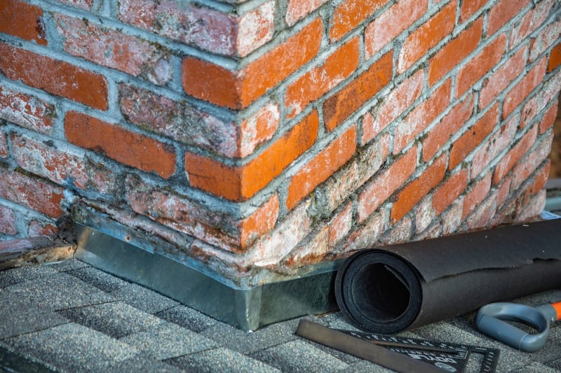 Lead flashing detail where a brick chimney meets the roof covering